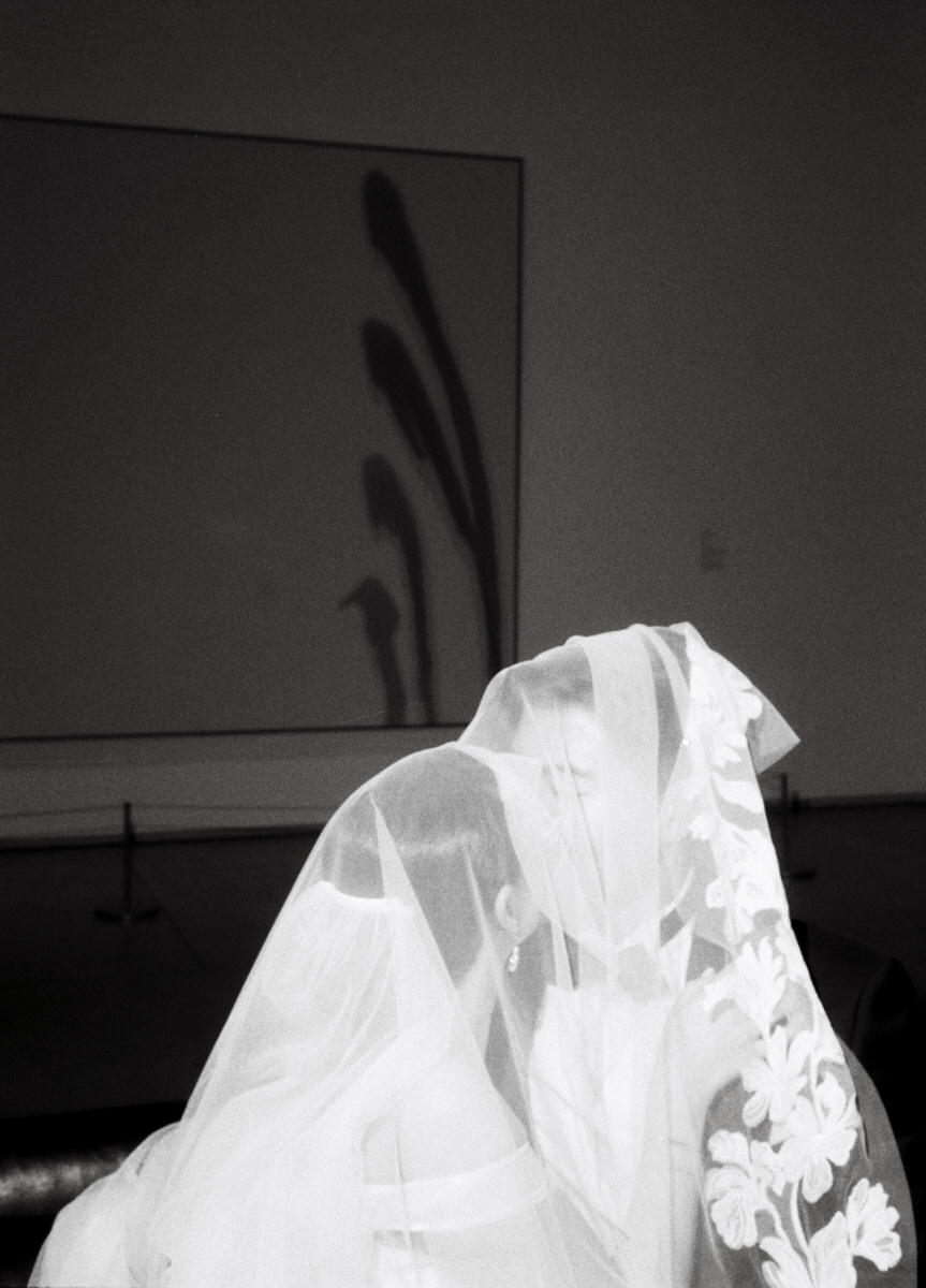 35mm film photo of a wedding couple underneath a floral veil at the AGO Art Gallery of Ontario