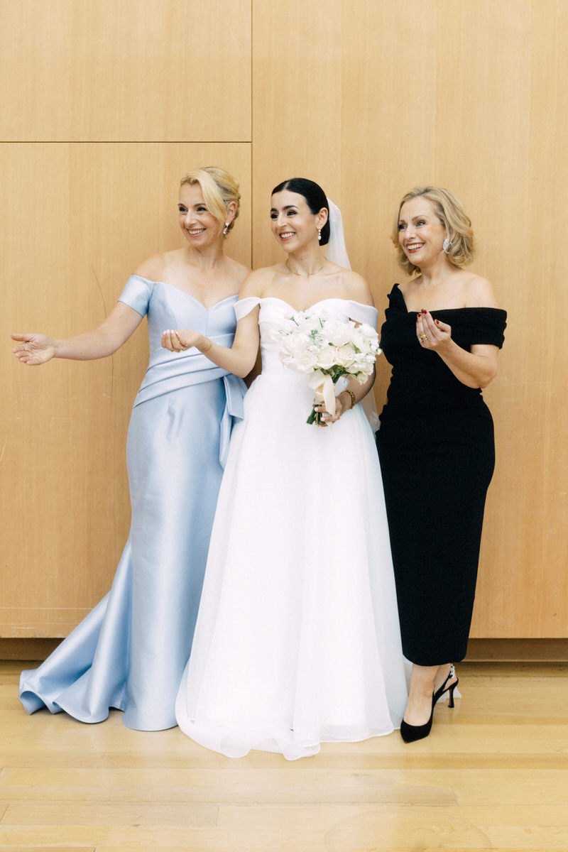 bride and family members coaxing others to take a photo with them