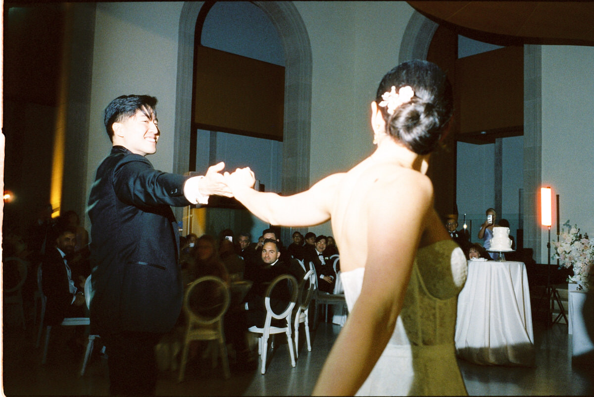 35mm film photo of a wedding couple smiling at each other during their first dance at the AGO Art Gallery of Ontario