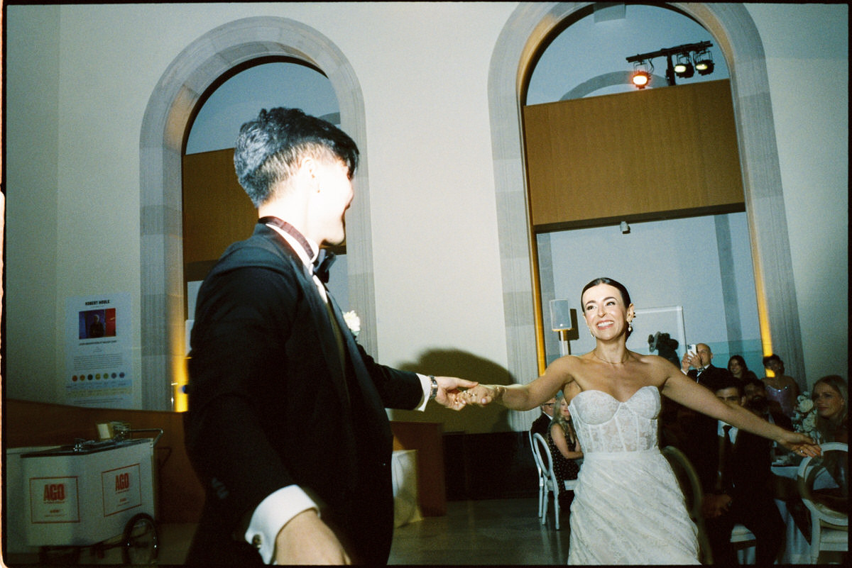 35mm film photo of a wedding couple smiling at each other during their first dance at the AGO Art Gallery of Ontario
