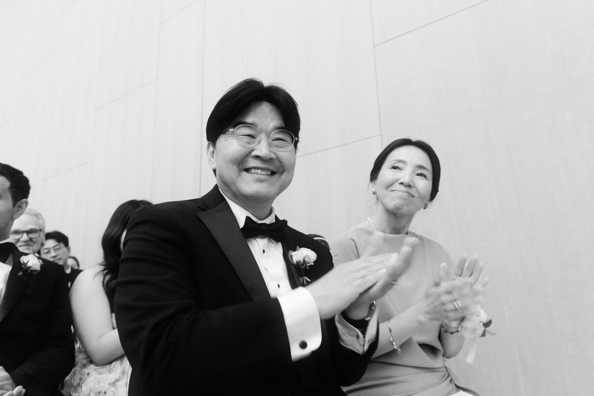 Asian parents clapping during an emotional wedding ceremony at the AGO in Toronto