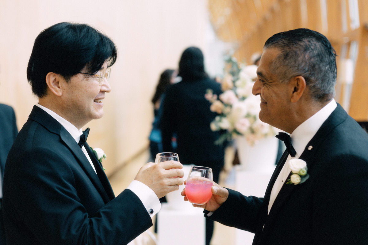 father of the groom and father of the bride clinking glasses during cocktail hour at the AGO Art Gallery of Ontario