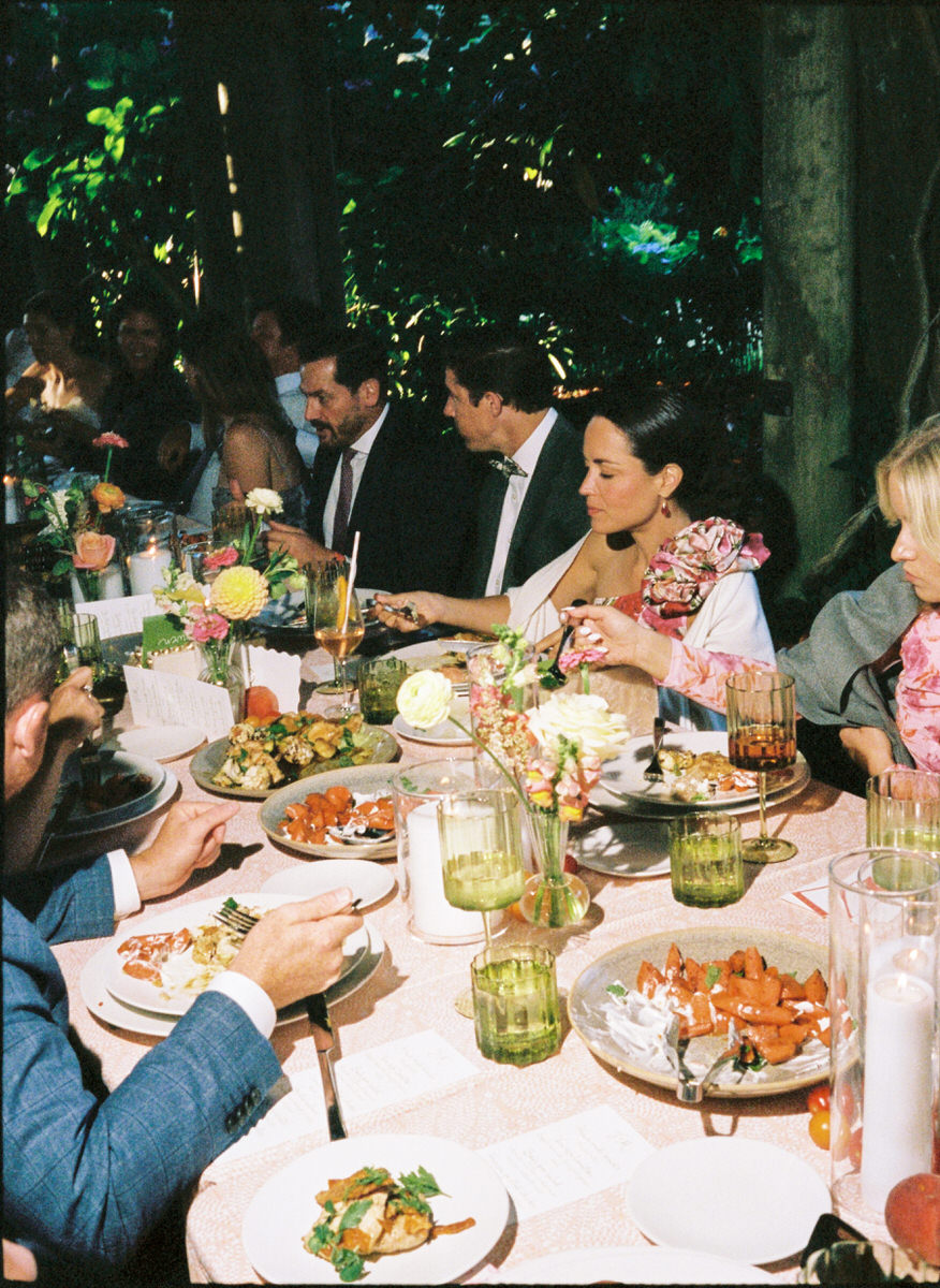 35mm film photo of guests enjoying a family style dinner under the arbour at UBC Botanical Garden