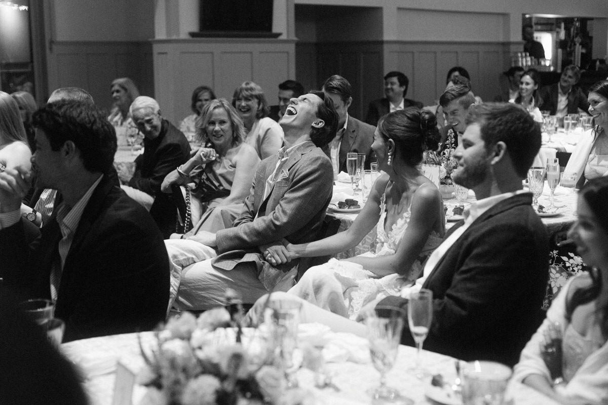 documentary moment of wedding couple laughing during speeches at the Vancouver Rowing Club