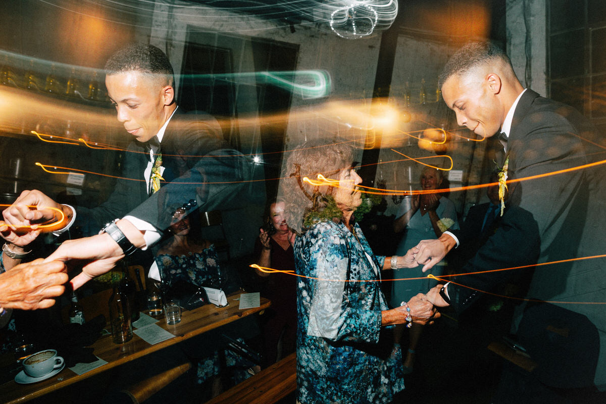 a groom and his grandmother dancing at his wedding. multiple exposures are used to enhance these fun and energetic moments