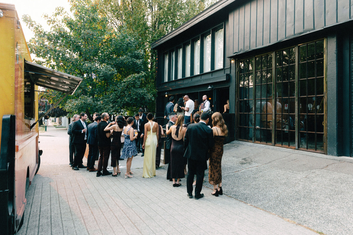 guests enjoying a cocktail reception outside la fabrique st george winery in vancouver. a food truck provides catering