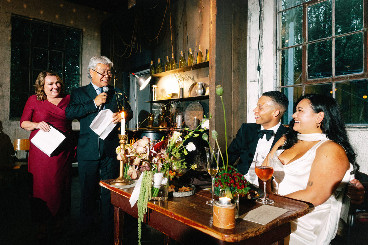 newlyweds reacting to speeches at their la fabrique st george wedding in vancouver