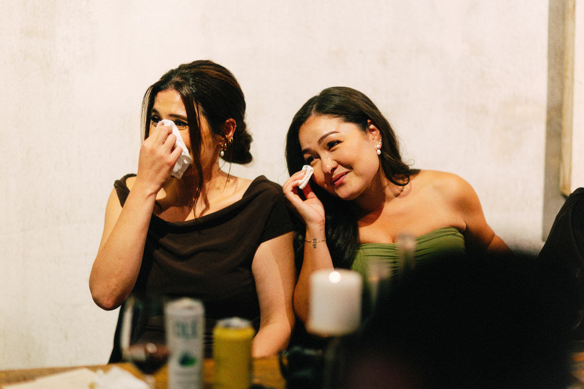 bridesmaids crying and wiping away tears during wedding speeches at la fabrique st george in vancouver