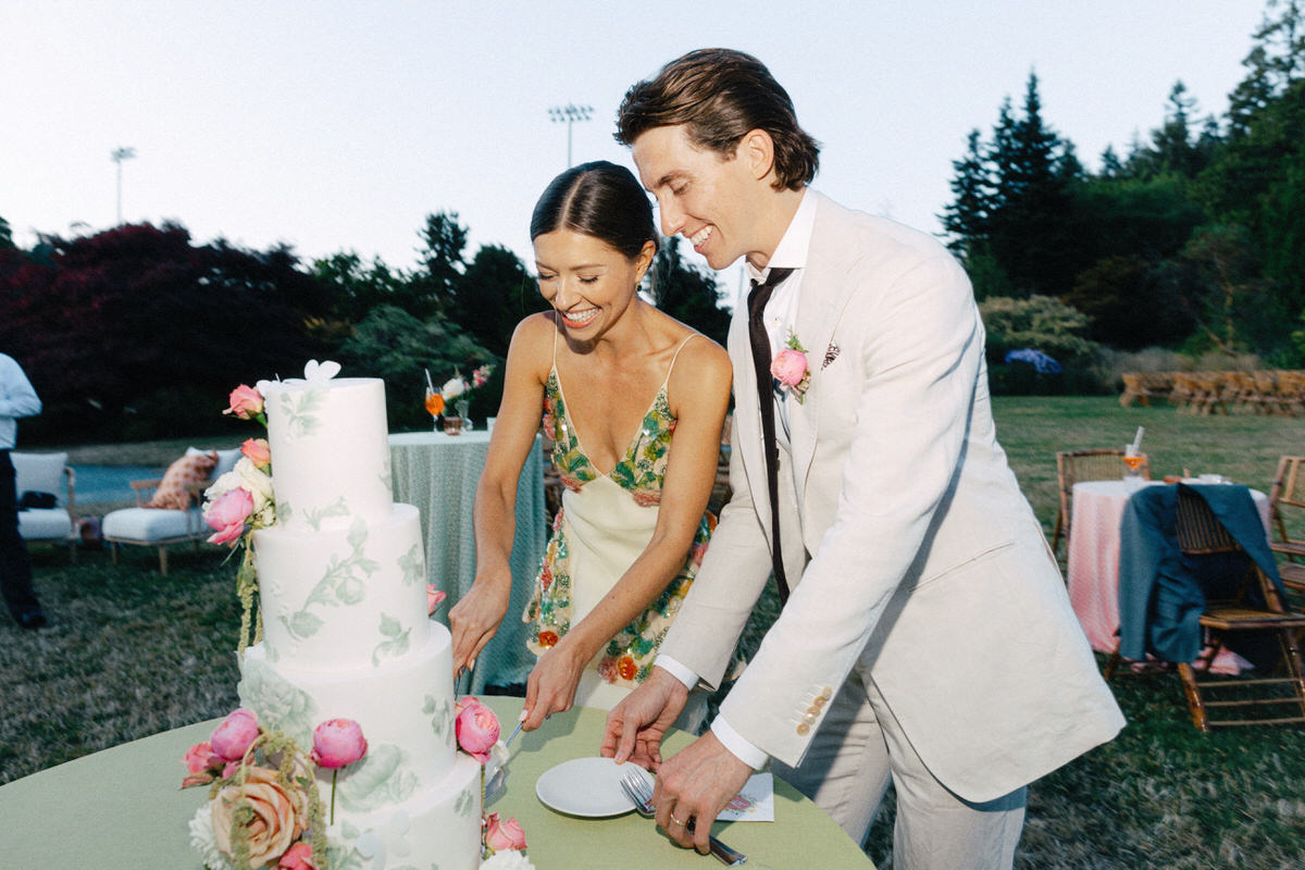 bride and groom cutting a multi tiered cake at their UBC Botanical Garden wedding